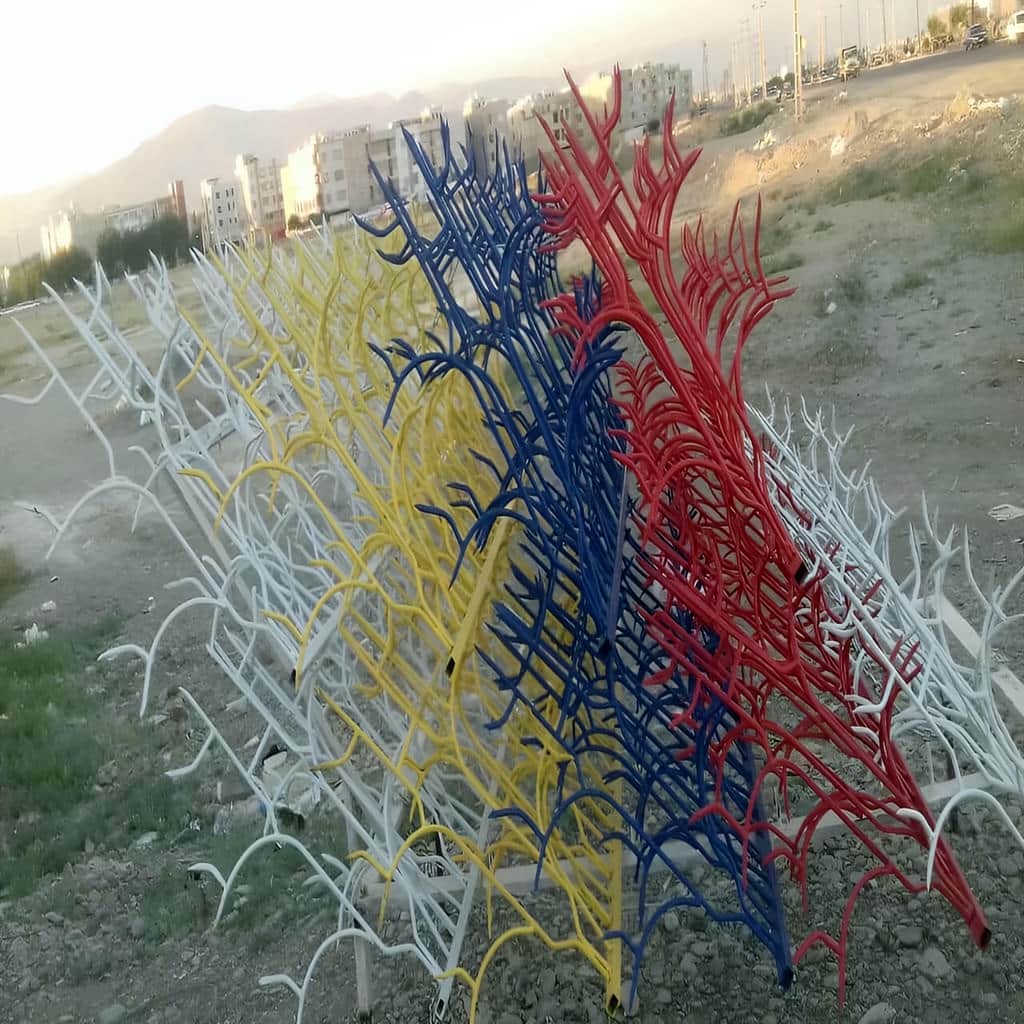 حفاظ آبشاری روی دیوار سنگی با میلگرد و شاخه منظم در یزد